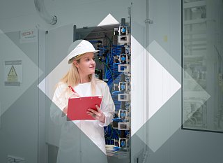 Frau mit Schutzhelm und Klemmbrett schreibt etwas